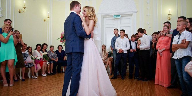 Супруги танцуют в зале бракосочетания